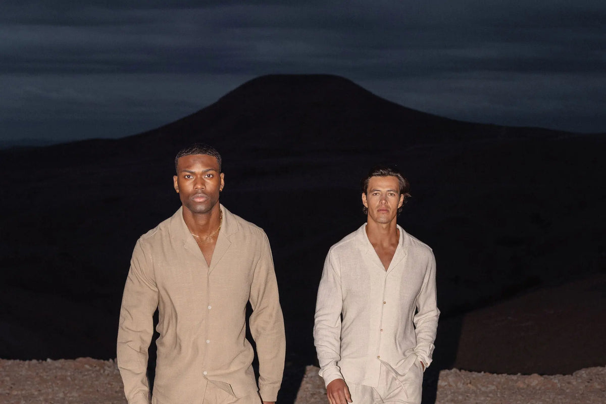 Deux hommes en chemise et pantalon en lin dans un paysage sec au crépuscule