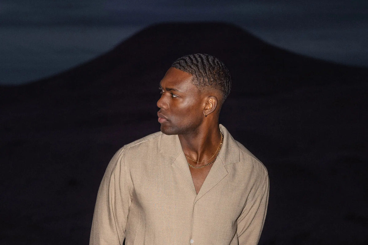 Homme en chemise et pantalon en lin dans un paysage désertique au crépuscule