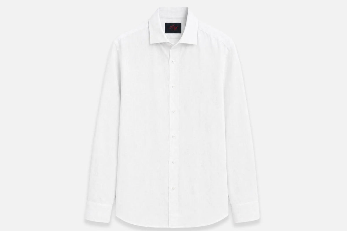 Chemise en lin blanche à plat sur fond clair, col ouvert et manches longues
