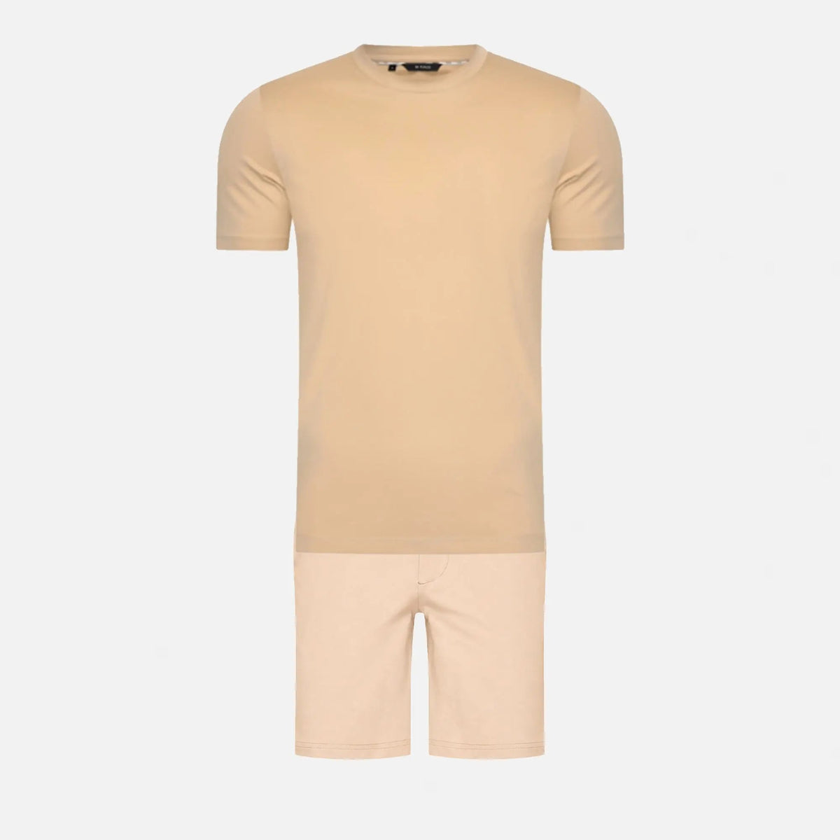 Ensemble de voyage posé à plat : t-shirt à col rond beige et short assorti, présentés l'un sous l'autre sur fond gris clair